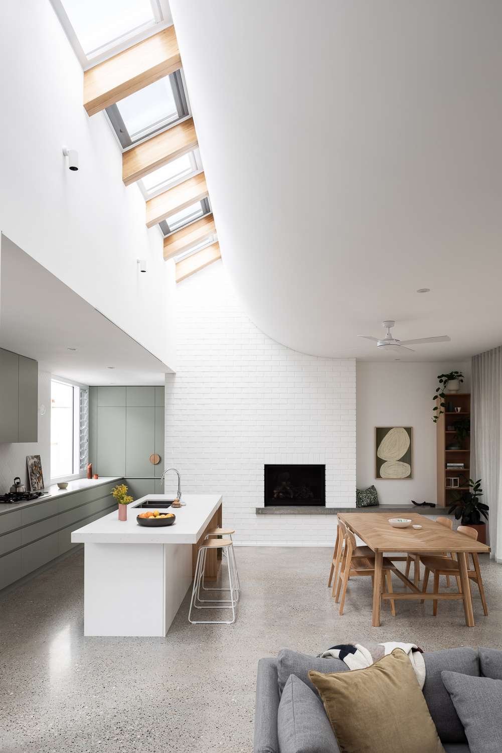 The Third by Dalecki Design showing kitchen and dining space with a large skylight overhead
