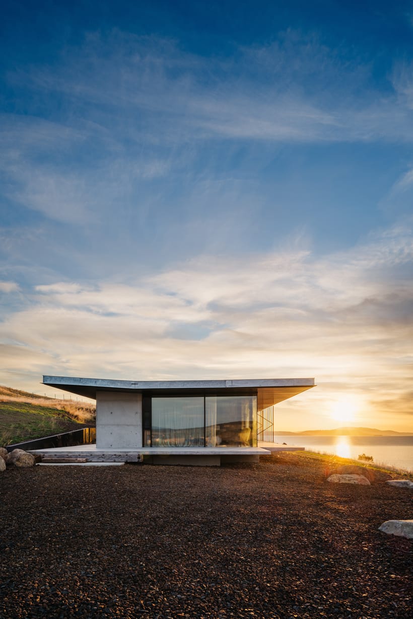 The Point Tasmania showing the exterior of the concrete house with the sunset in the background