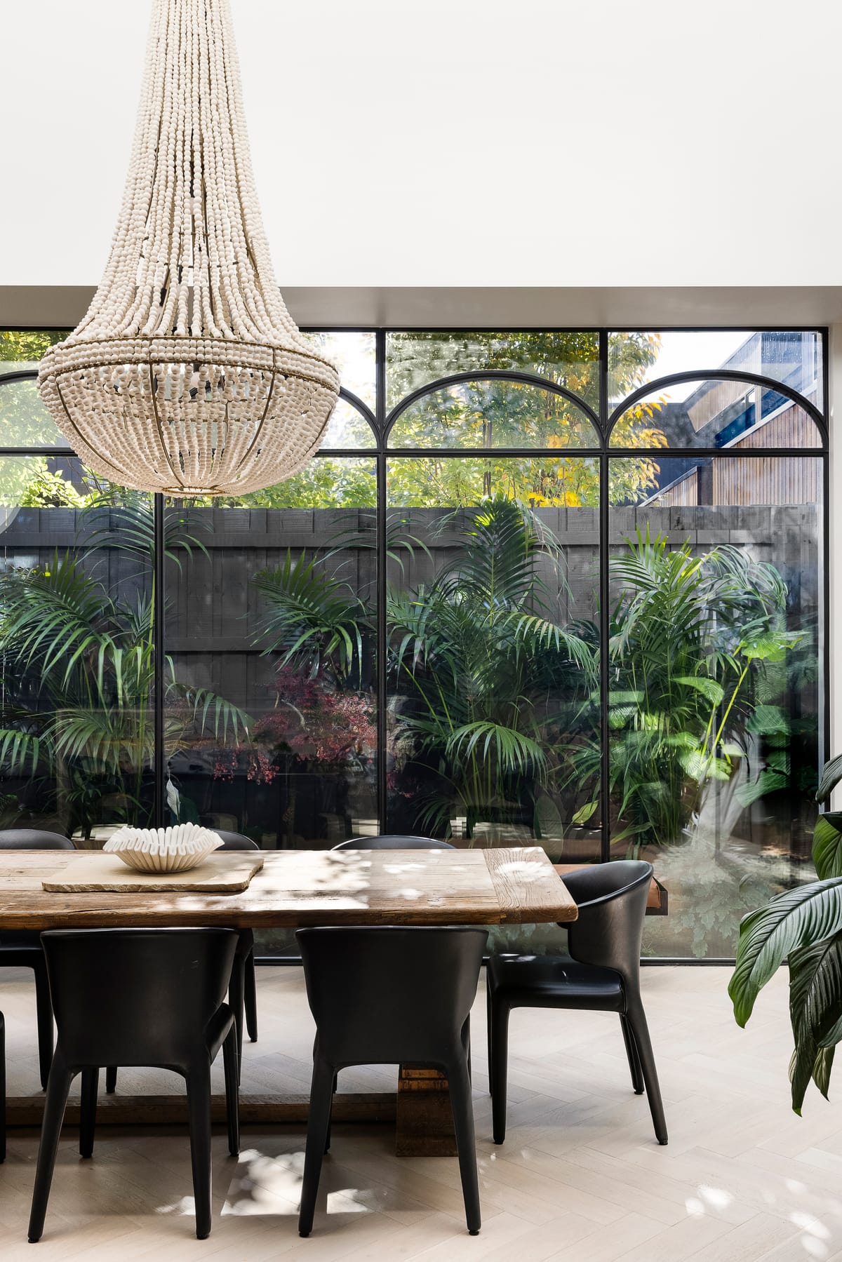 Goldsmith Residence by C.Kairouz Architects. Photography by Spacecraft. Dining table overlooking lush garden.