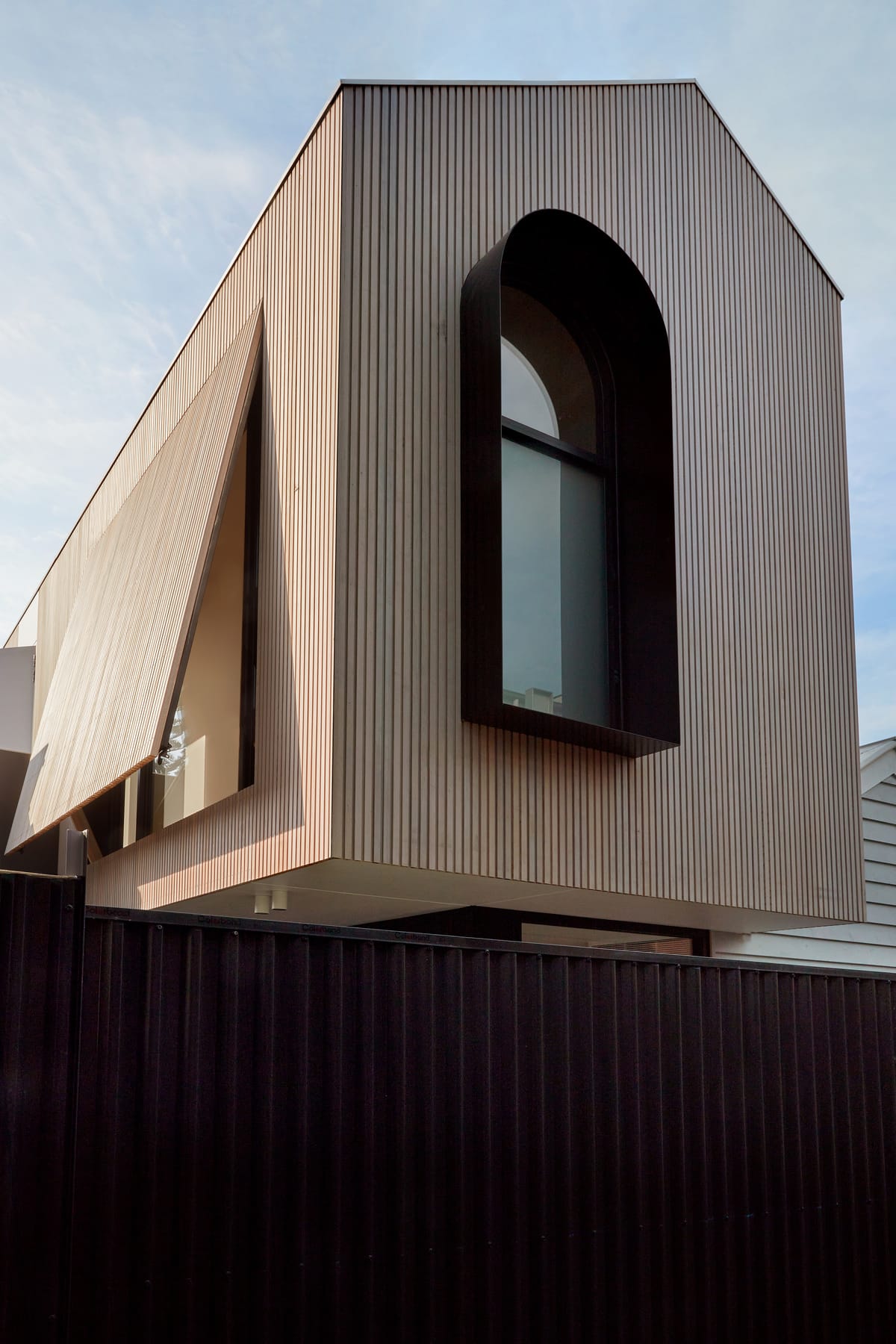 The Full Monty by FYC Architects. Photography by Stephanie Rooney. Gabled, timber clad second storey with black window. 
