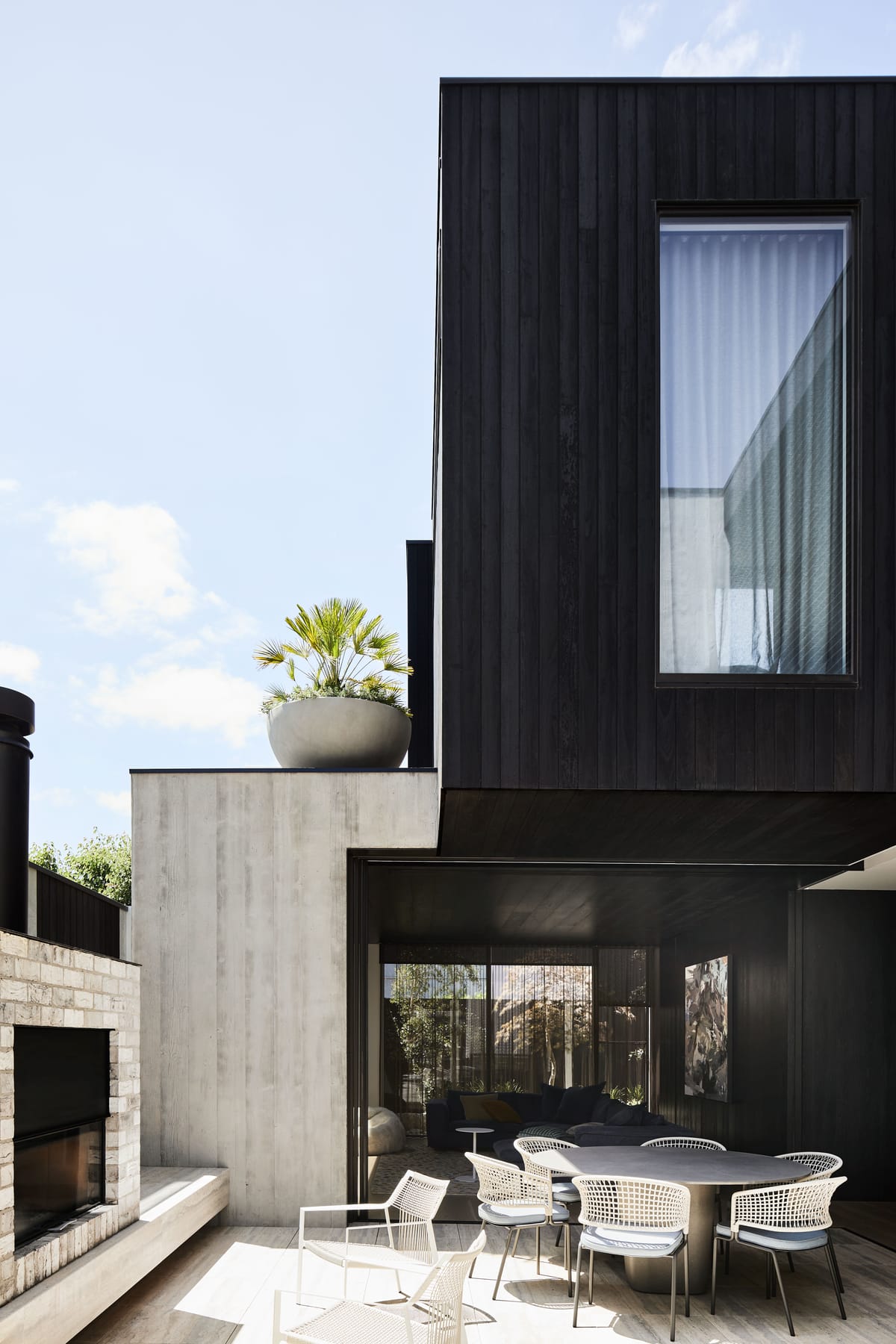 The Split Home by Seidler Group. Copyright of Seidler Group. Concrete courtyard. Double storey black clad home. 