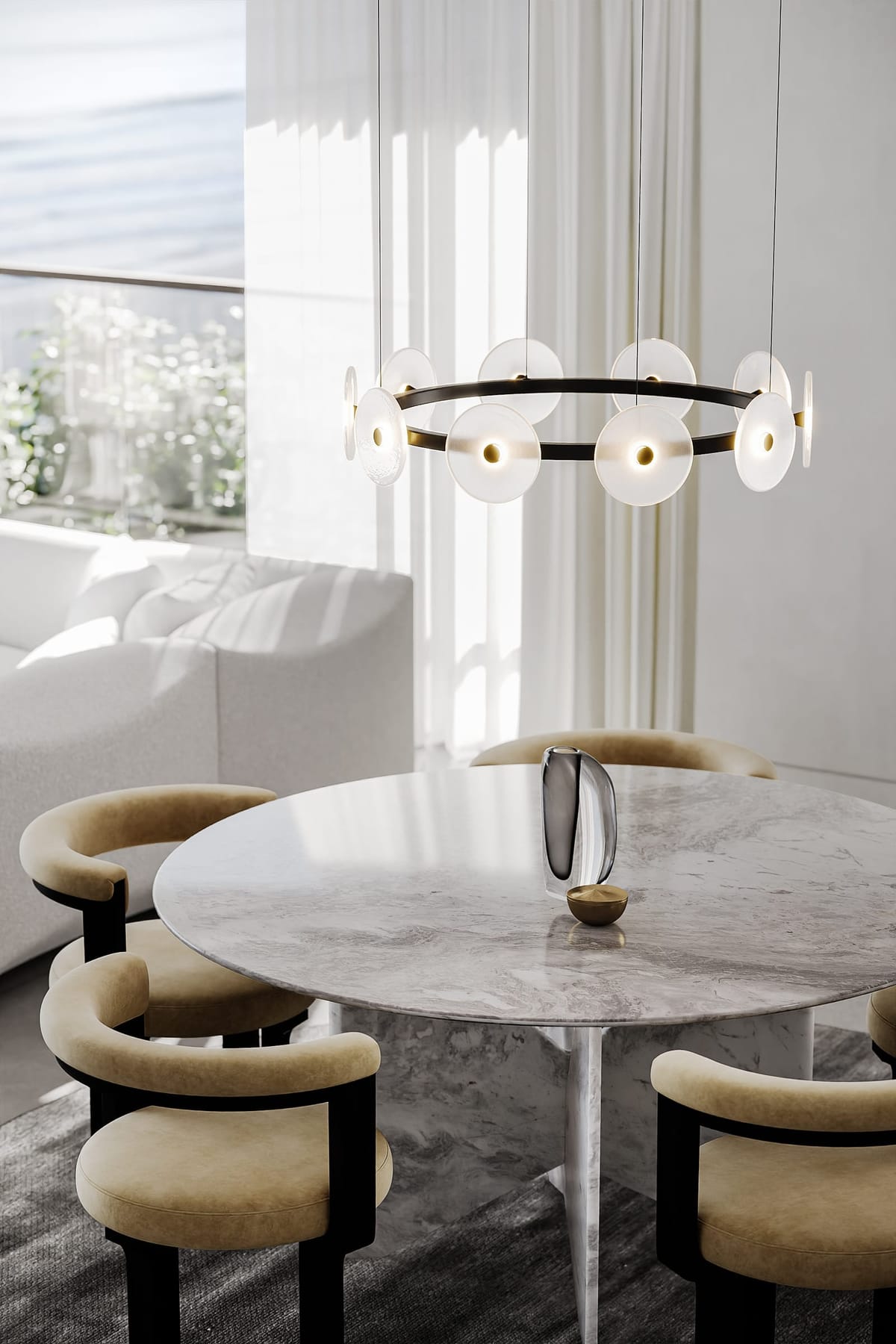 Circular ring light with glass circle lights hanging on gold ring. Marble dining table underneath light. 